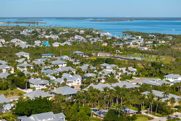 Premium housing development in the USA. Expensive waterfront houses between green palm trees in Boca Grande, small town on Gasparilla Island in southwest Florida