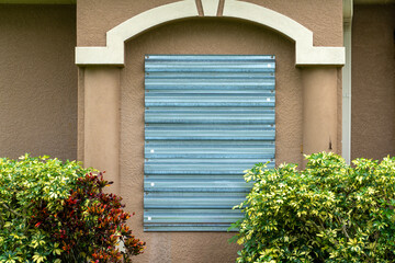 Residential house in Florida with reinforced storm shutters for hurricane protection. Window covering as disaster preparedness