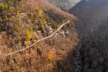 Scenic journey through Highlands Road in North Carolina. Rocky mountainsides and fall forest canopy create a stunning autumn drive