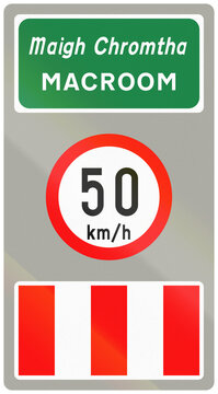 Road sign used in Ireland - Town name Macroom in Gaelic and English and speed limit