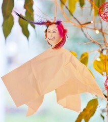 &Auml;ngstliche Federnfee h&auml;ngt in Gr&uuml;npflanze