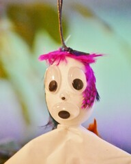 &Auml;ngstliche Federnfee h&auml;ngt in Gr&uuml;npflanze