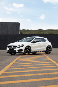 White Mercedes-Benz GLA 45 AMG front three quarter, German performance car on sunny day
