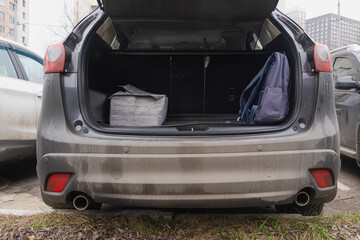 Open trunk of family car with storage box and backpack inside