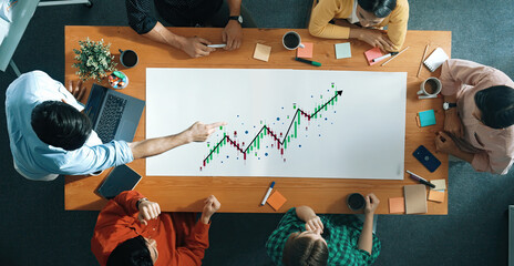 A diverse team engages in a brainstorming session, passionately discussing market trends and strategies while analyzing financial data on a large table. Trope