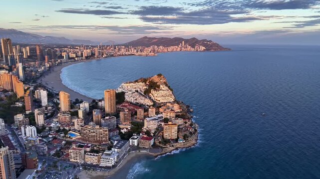 aerial coastline bay at sunrise golden light over beachside city curved shoreline and calm blue ocean