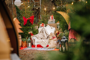 Festive outdoor holiday scene featuring a cozy seating area adorned with Christmas decorations,...