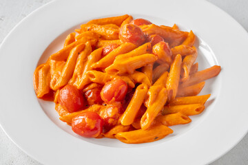 Penne pasta with roasted bell pepper emulsion cherry tomatoes Parmesan and herbs