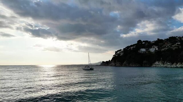 Aerial drone view, flying over the sea and sky with clouds at sunset with lonely boat sailing at Mediterranean, 4K nature background	