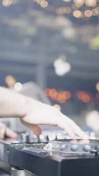 Close-up of DJ hands mixing tracks on a professional controller in a vibrant nightclub atmosphere with colorful lights and energetic electronic dance music vibes
