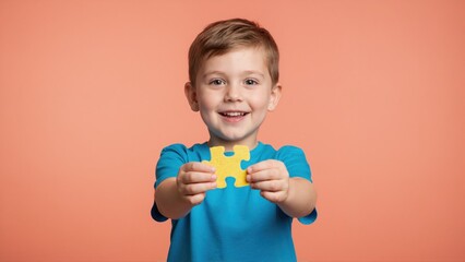 Smiling little boy holding yellow puzzle piece. Happy child playing developmental game. Autism awareness and solution concept with copy space