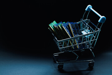 Laptop ddr memory modules in toy shopping cart on black background