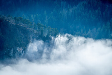 mountain landscape with high mountain peaks in snow and a foggy valley down