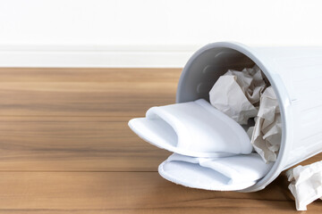 ゴミ箱に入った使い捨てのスリッパ