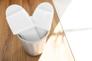 ゴミ箱に入った使い捨てのスリッパ