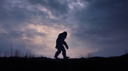 Fototapeta premium A large creature walks along a hill against a backdrop of dark clouds and a fading sunset. The scene shows the creature in profile creating a strong silhouette.
