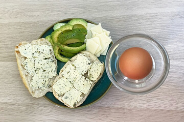 Healthy Breakfast with Boiled Egg, Avocado, and Herb Butter Bread