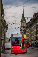 Red tram and arcades under festive lights in the Old Town Bern, Switzerland