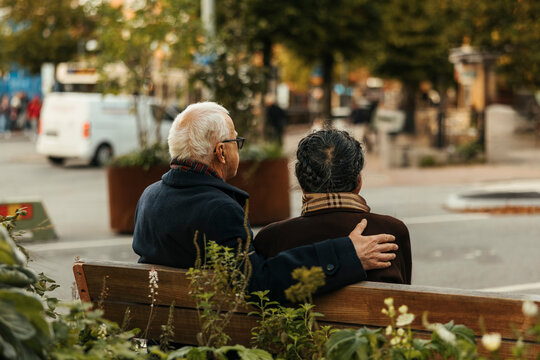 Rear view of senior couple spending leisure time sitting on bench