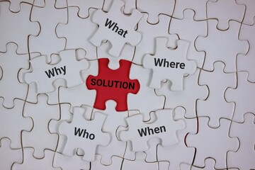 white puzzle layout highlights a central red piece labeled SOLUTION surrounded by pieces bearing...