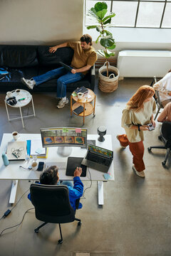 High angle view of young male programmer using desktop PC while working in tech office