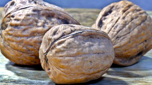 Heap of walnuts in shell, close-up, top view. Healthy eating. Harvest, agriculture. Walnuts, selective focus, background