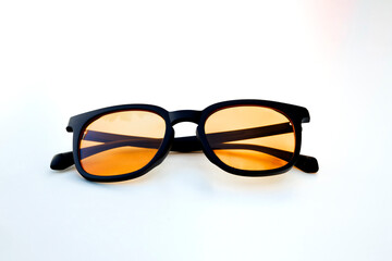 Symmetrical view of amber tinted glasses with black frame, designed to filter blue light and reduce strain from extended digital use.