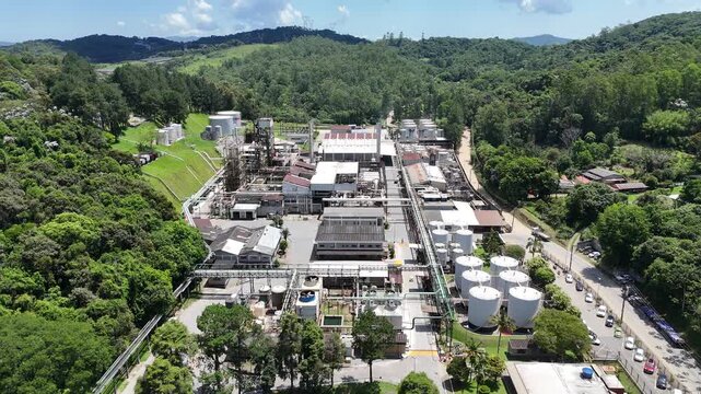 Imagem a&eacute;rea de complexo petroqu&iacute;mico em plena opera&ccedil;&atilde;o, destacando tanques, tubula&ccedil;&otilde;es e estruturas industriais, simbolizando produ&ccedil;&atilde;o energ&eacute;tica, qu&iacute;mica pesada e atividade econ&ocirc;mica estrat&eacute;gica