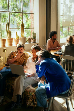 Team of tech experts discussing ideas with each other while working in startup office