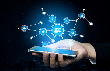 A close-up view of a hand holding a smartphone, with various digital icons floating above representing technology, communication, and modern connectivity solutions. Tessel