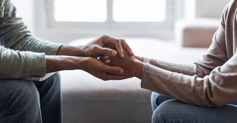 Cropped of African American man psychologist holding hands of woman patient provide professional...