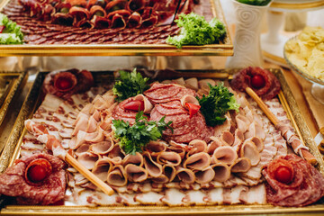 Assorted deli cold cuts platter on golden tray