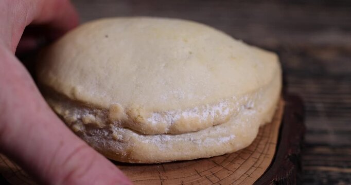 shortbread bun with cottage cheese filling on a wooden board on the table, soft pastries stuffed with cottage cheese and sugar are on the board