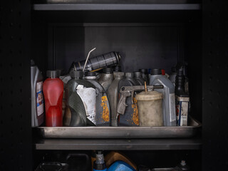 Automotive workshop storage shelf displaying various motor oils lubricants and maintenance fluids in organized arrangement