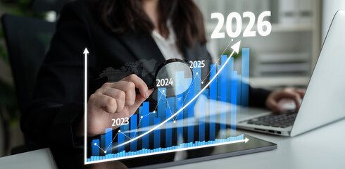 A business professional examines growth trends using a laptop, highlighting data visualization and projections for the year 2026 to strategize future success. Tessel