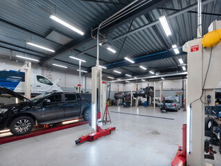 Automotive workshop interior showing pickup truck on hydraulic lift with multiple service bays and professional equipment © Victor