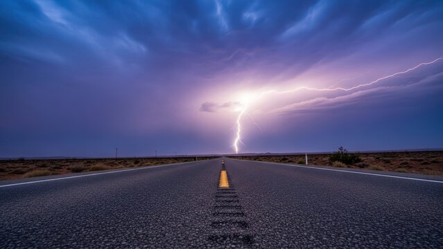 Asphalt road stretches into distance, illuminated by dramatic lightning storm against dusk sky