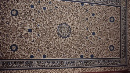 Intricate ceiling detail with ornate geometric patterns, intricate carvings, and script border