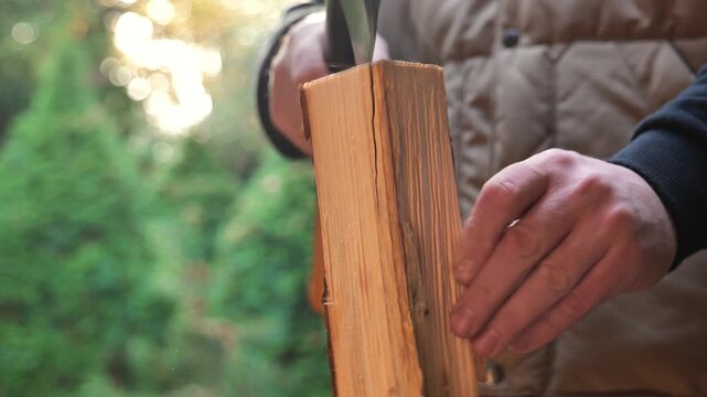 man chops wood on a large stump outside. close-up of the axes work. Heating season. Solid heating fuel.Preparing firewood for the heating season