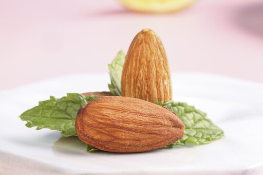 Fresh Almonds with Mint Leaves on White Plate