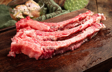 Fresh Raw Pork Chops on Dark Wood Cutting Board