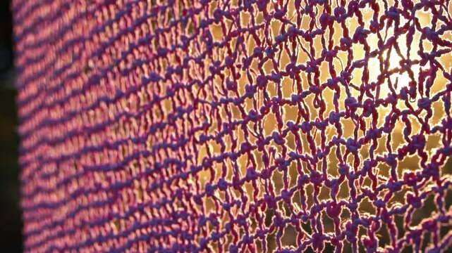 A colorful textile pattern displays intricate weaving details, with vibrant colors of purple and blue. This textile pattern creates a visually interesting backdrop, enhancing the warm atmosphere.
