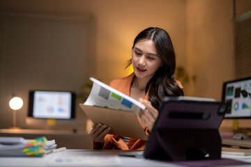 Businesswoman analyzing reports working late in office