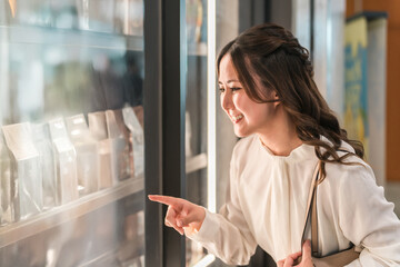 A businesswoman enjoying shopping while looking at products in a shop window