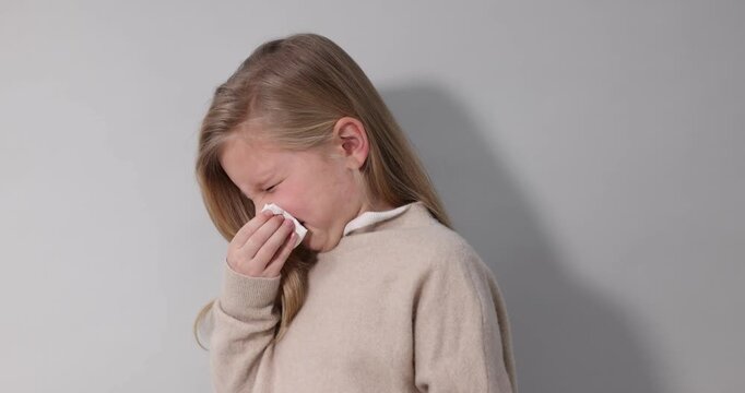 Little girl with runny nose on light background. Cold symptom
