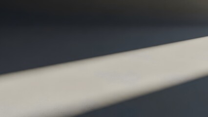 Abstract image of a bright diagonal light beam cutting across a dark background.