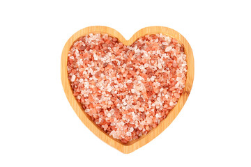 Top view of a wooden heart bowl with Himalayan salt crystals isolated on a white background