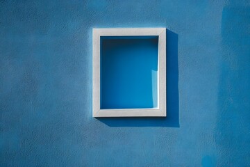 Blue wall with an empty white picture frame and a minimalist square panel.

