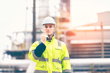 Engineers workers with tablet in a refinery - oil processing equipment and machinery, Industry zone gas petrochemical. Factory oil storage tank and pipeline. Workers in the refinery construction.