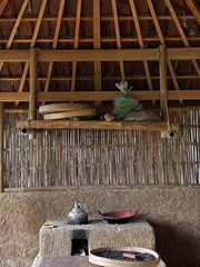 Obraz premium Traditional Clay Wood-Fired Stove with Metal Kettle and Clay Pan in a Rustic Rural Kitchen